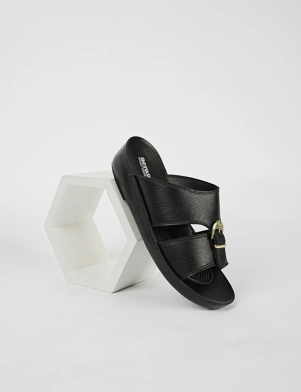 Black sandal with gold buckle on a white background