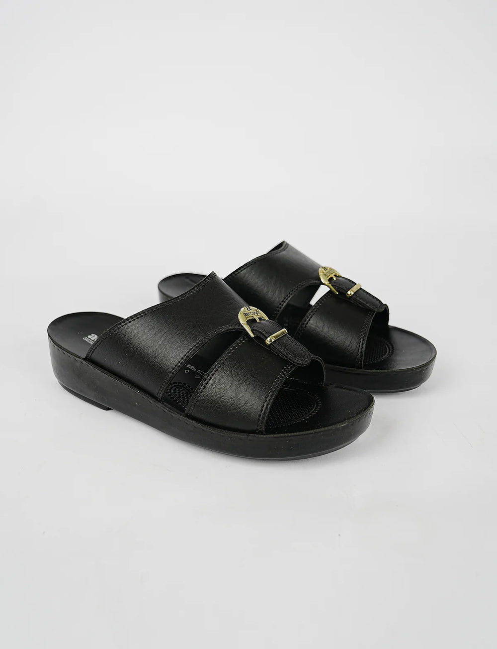 Black sandals with gold buckles on a light gray background