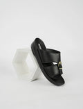 Black sandal with gold buckle on a white background
