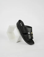 Black sandal with gold buckle on a white background