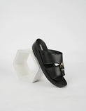 Black sandal with gold buckle on a white background
