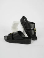 Black sandals with gold buckles on a white background