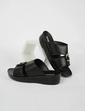 Black sandals with gold buckles on a white background